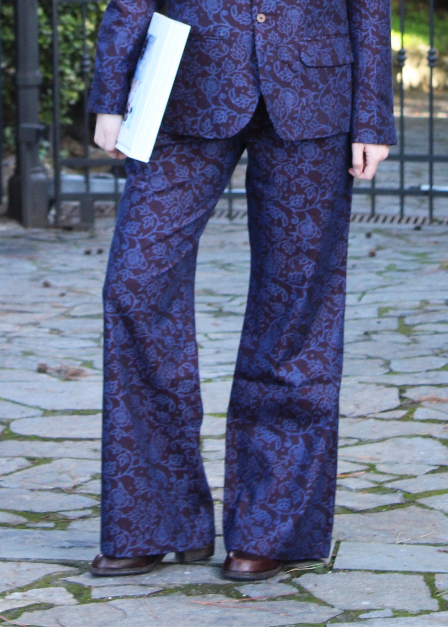 1970 Dark Aubergine in cotone di IGI AMA, fantasia damascata celeste, pantaloni in cotone color melanzana scuro con pinces anteriori. Vestibilità regolare, disponibili nelle taglie S e M, la modella è alta 170 cm e indossa la taglia S. Prodotto in India con un design elegante e versatile. Solo lavaggio a secco, stiratura a bassa temperatura, non candeggiare.
