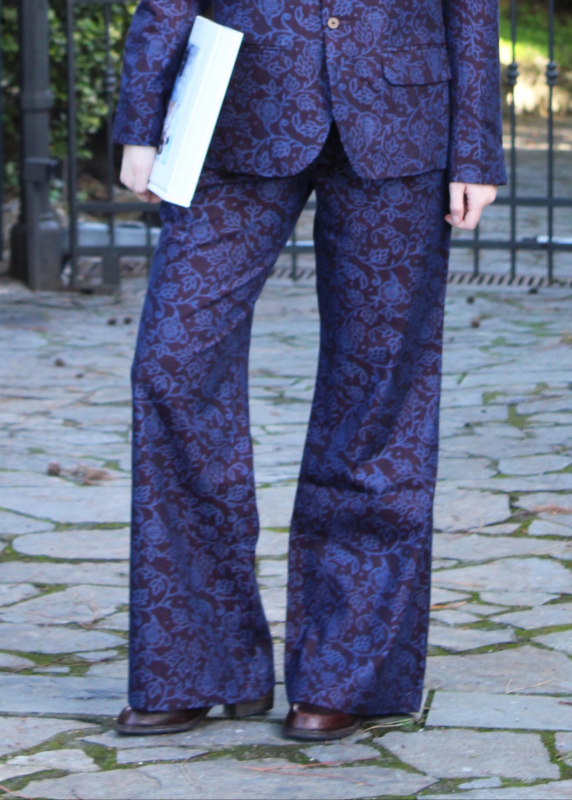 1970 Dark Aubergine in cotone di IGI AMA, fantasia damascata celeste, pantaloni in cotone color melanzana scuro con pinces anteriori. Vestibilità regolare, disponibili nelle taglie S e M, la modella è alta 170 cm e indossa la taglia S. Prodotto in India con un design elegante e versatile. Solo lavaggio a secco, stiratura a bassa temperatura, non candeggiare.