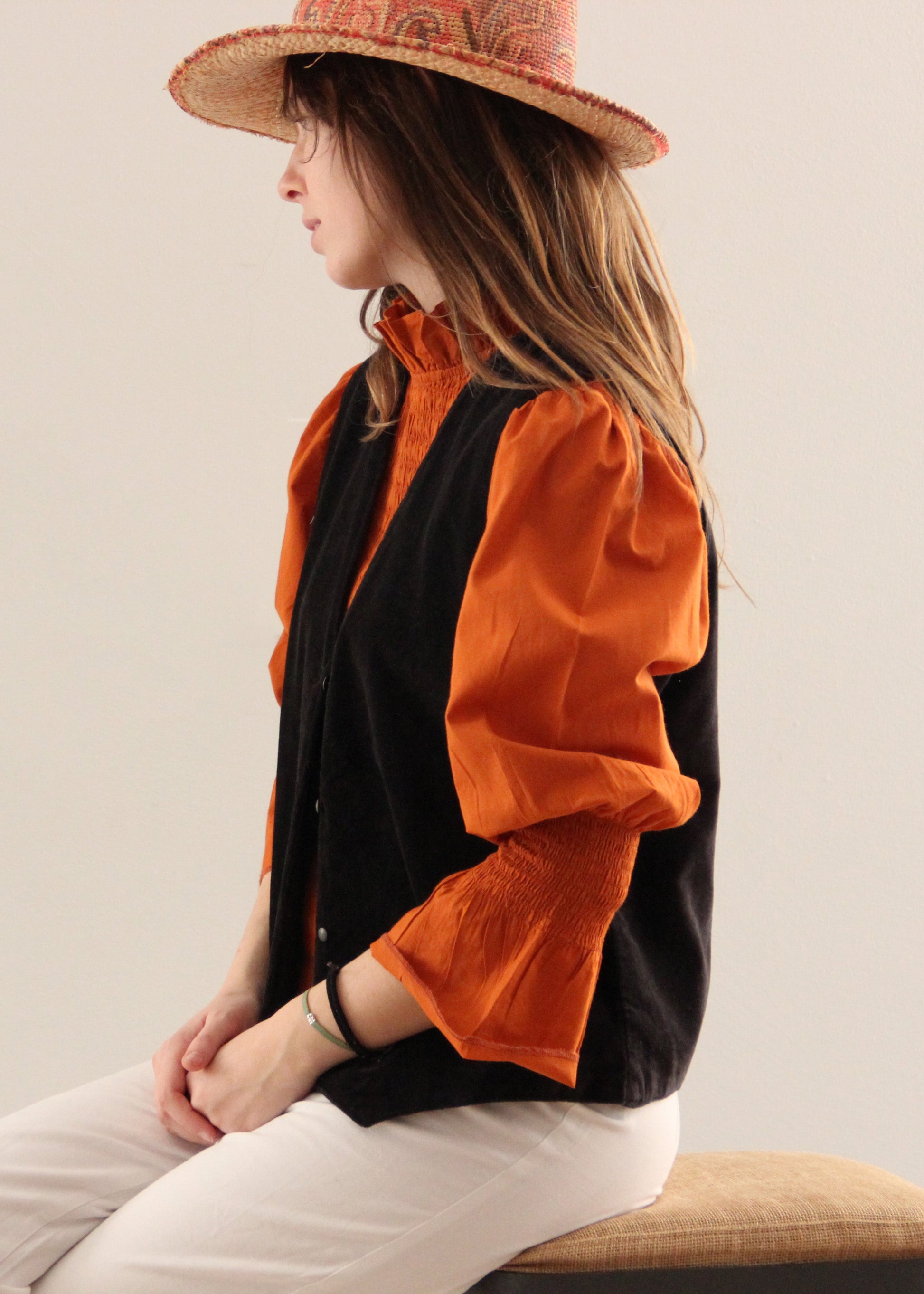 Gilet Polo in velluto nero di IGI Ama, smanicato in velluto con fodera in cotone 100% a fantasia arancione, bianca e verde. Realizzato in India, taglia unica (torace 50 cm per lato, lunghezza 60 cm, giromanica 26 cm). Stile elegante con un tocco boho chic. Lavare a secco, stirare a bassa temperatura, non candeggiare.