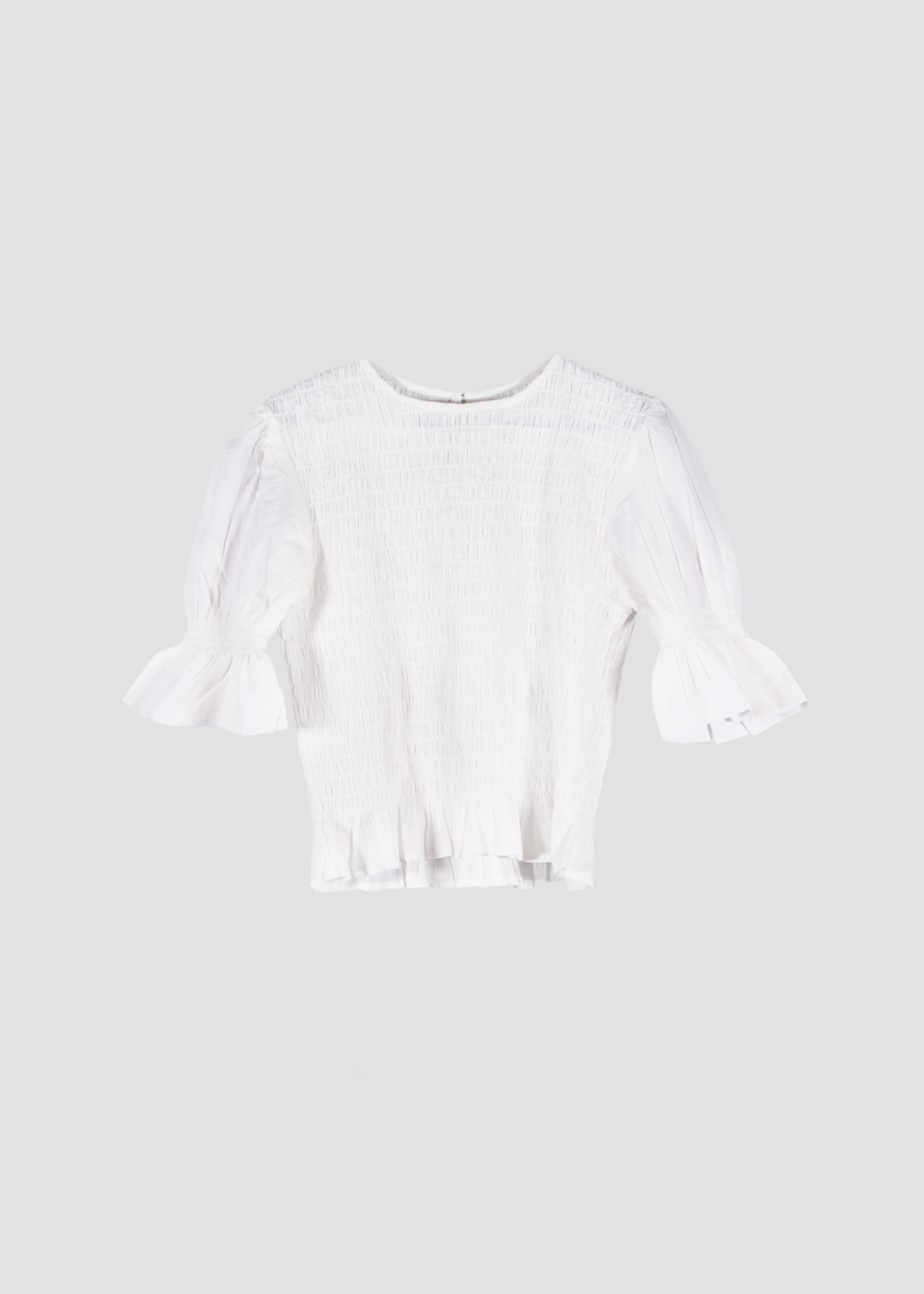 Holi Blouse – Camicetta bianca a maniche corte, realizzata in 100% cotone con maniche a sbuffo e arricciature elastiche su busto e maniche. Vestibilità elasticizzata e confortevole, adatta a tutte le corporature. Taglia unica. Prodotta eticamente in India. Cura delicata: lavare a 30°C, stirare a bassa temperatura.