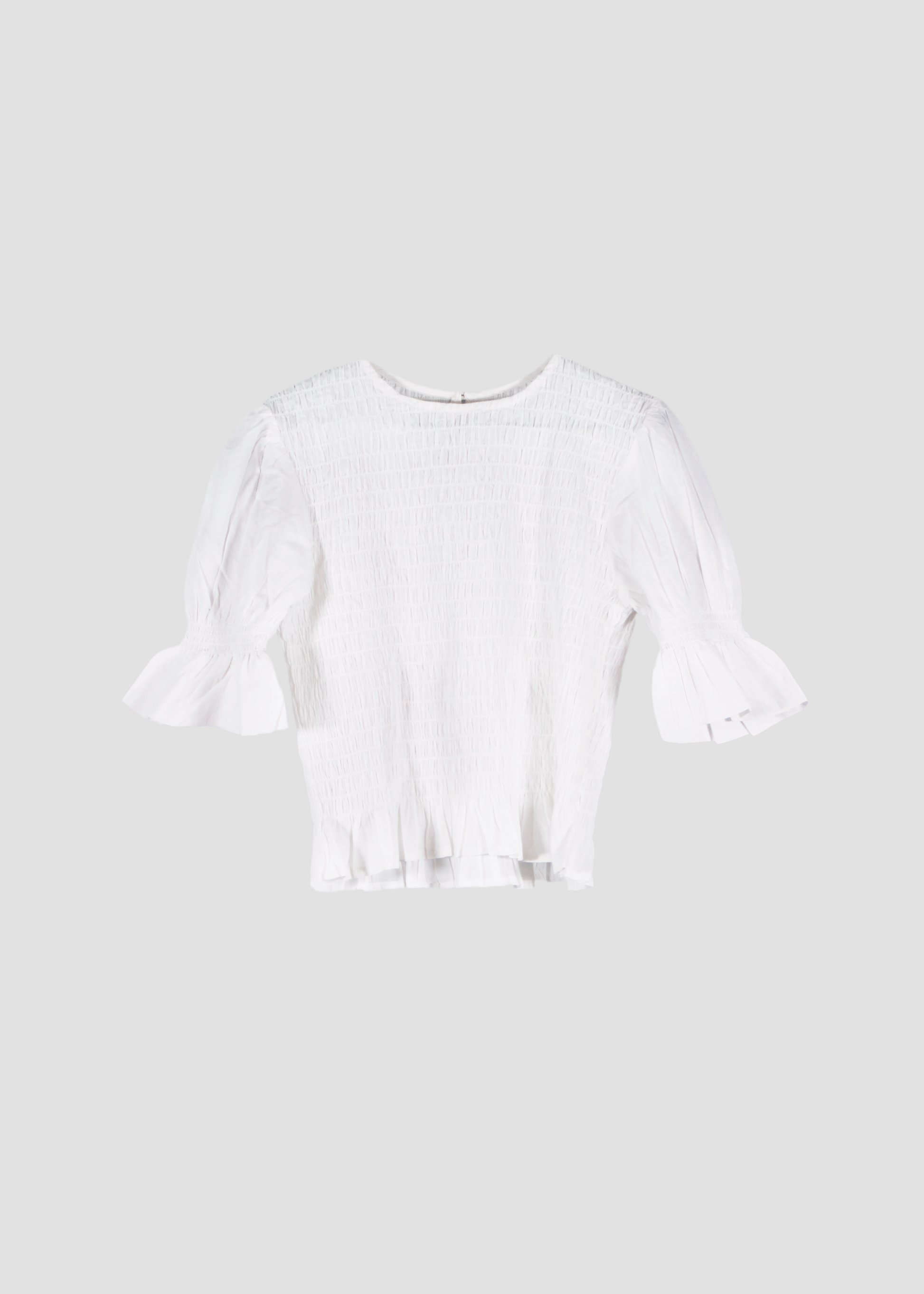 Holi Blouse – Camicetta bianca a maniche corte, realizzata in 100% cotone con maniche a sbuffo e arricciature elastiche su busto e maniche. Vestibilità elasticizzata e confortevole, adatta a tutte le corporature. Taglia unica. Prodotta eticamente in India. Cura delicata: lavare a 30°C, stirare a bassa temperatura.