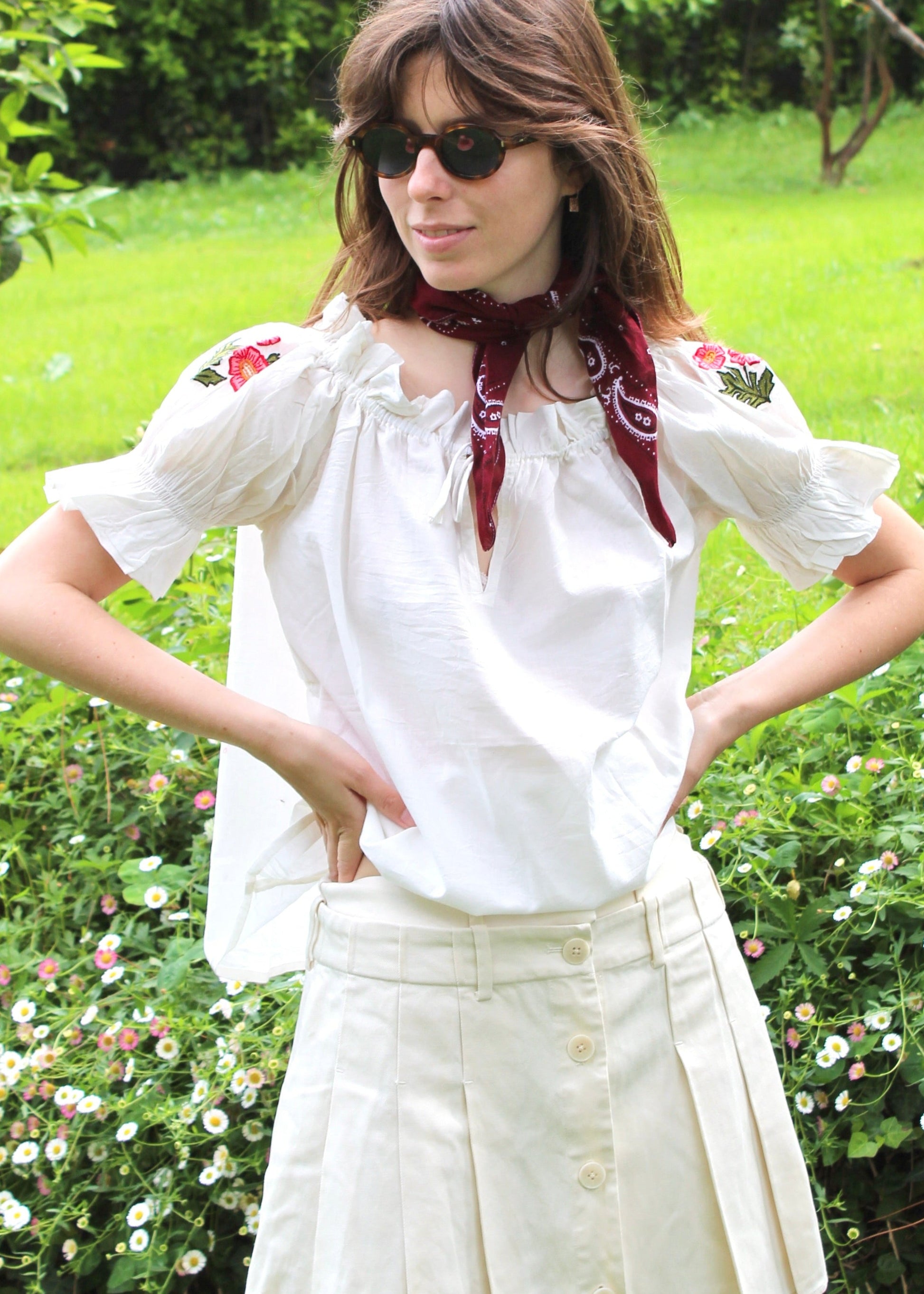Pimpa Shirt di IGIAMA, blusa arricciata in 100% cotone con laccetto sullo scollo, maniche corte a sbuffo elasticizzate e fiori di montagna cuciti a mano, elastica e adatta a tutte le corporature, prodotta in India, perfetta per un look naturale e romantico.