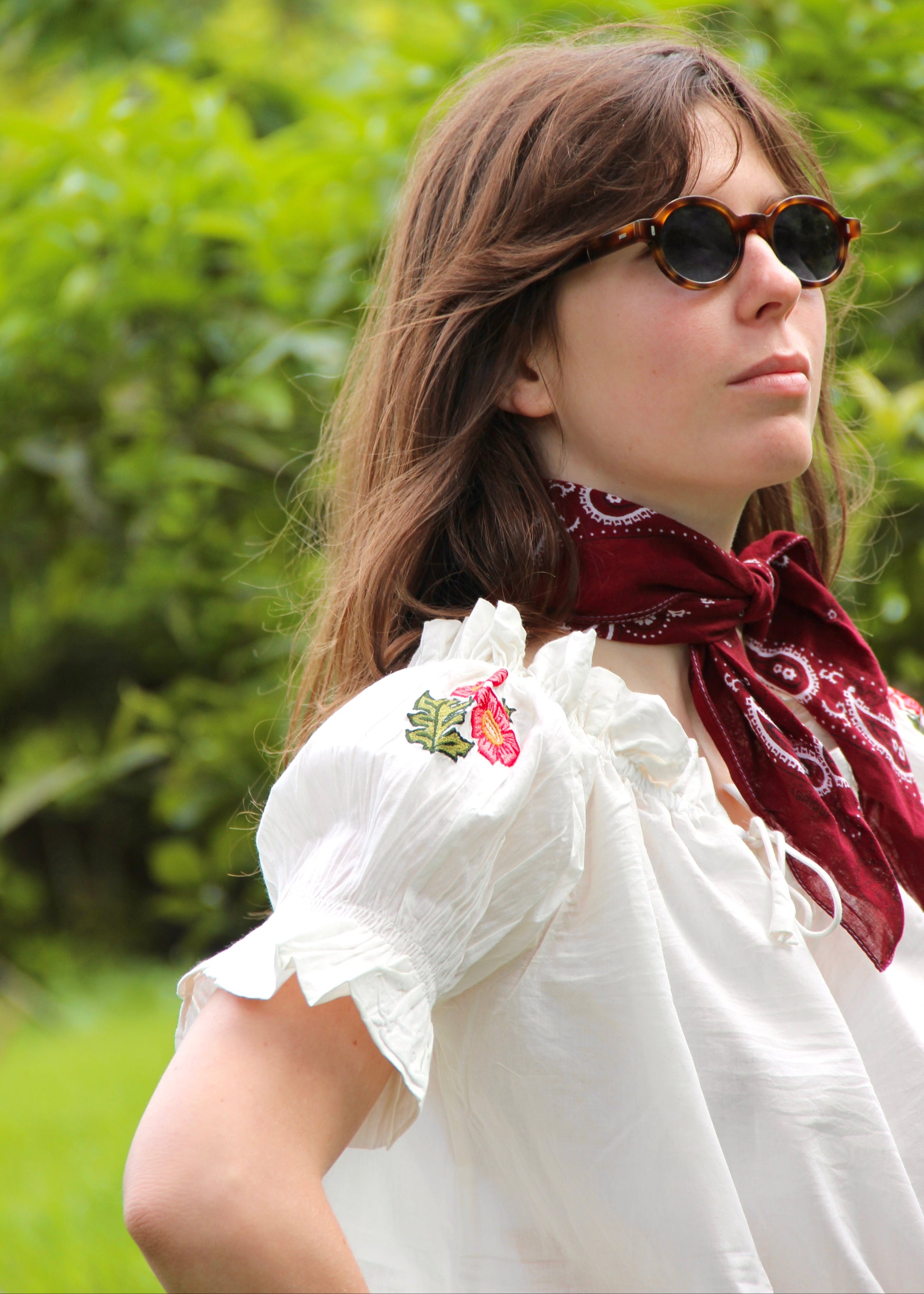 Pimpa Shirt di IGIAMA, blusa arricciata in 100% cotone con laccetto sullo scollo, maniche corte a sbuffo elasticizzate e fiori di montagna cuciti a mano, elastica e adatta a tutte le corporature, prodotta in India, perfetta per un look naturale e romantico.