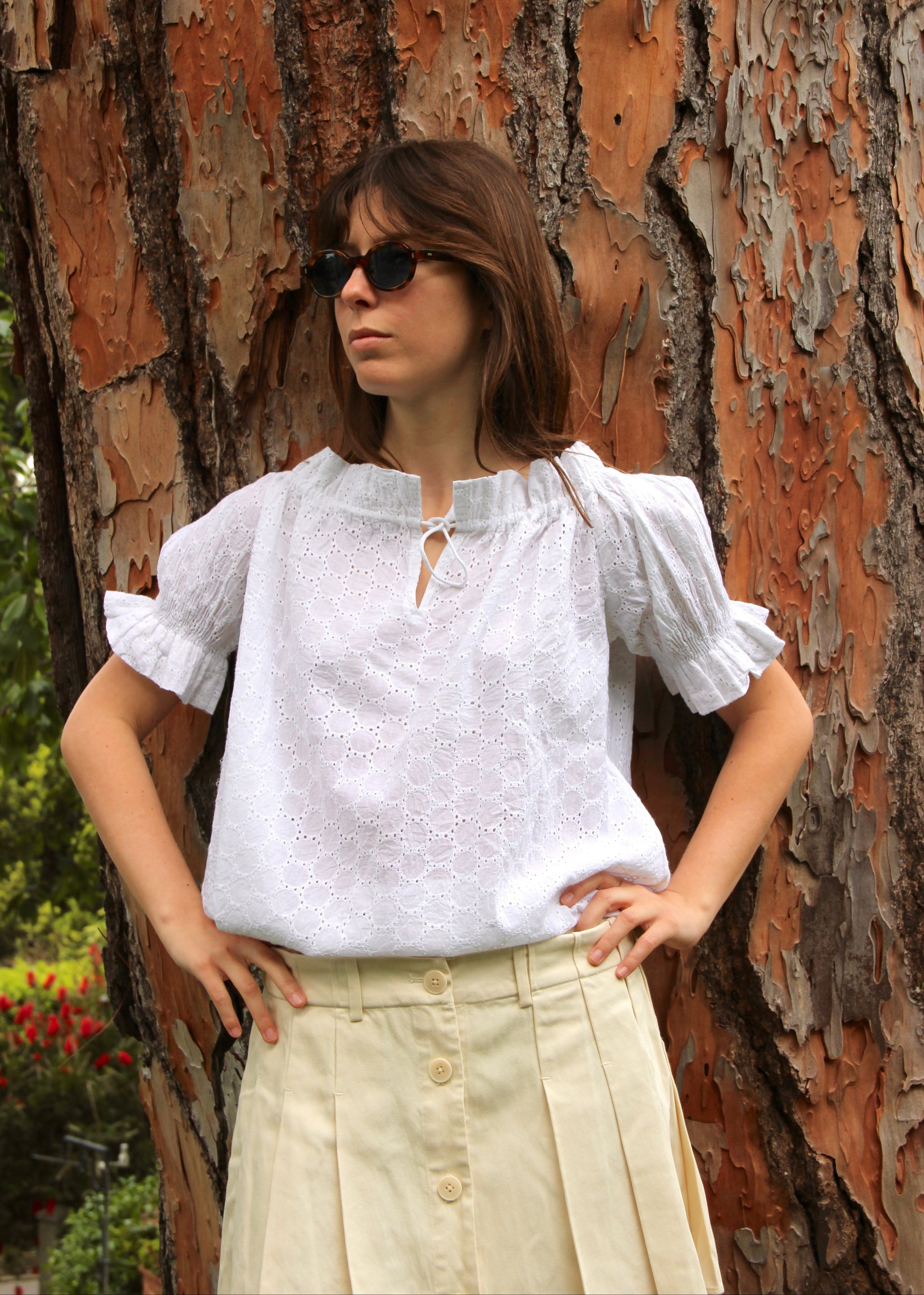 Blusa arricciata da donna in cotone bianco con trama sangallo, modello Pimpa shirt di IGI AMA, 100% cotone, con laccetto sullo scollo e maniche elasticizzate a sbuffo, tessuto elastico che si adatta a tutte le corporature, prodotta in India, ideale per look estivi e casual.