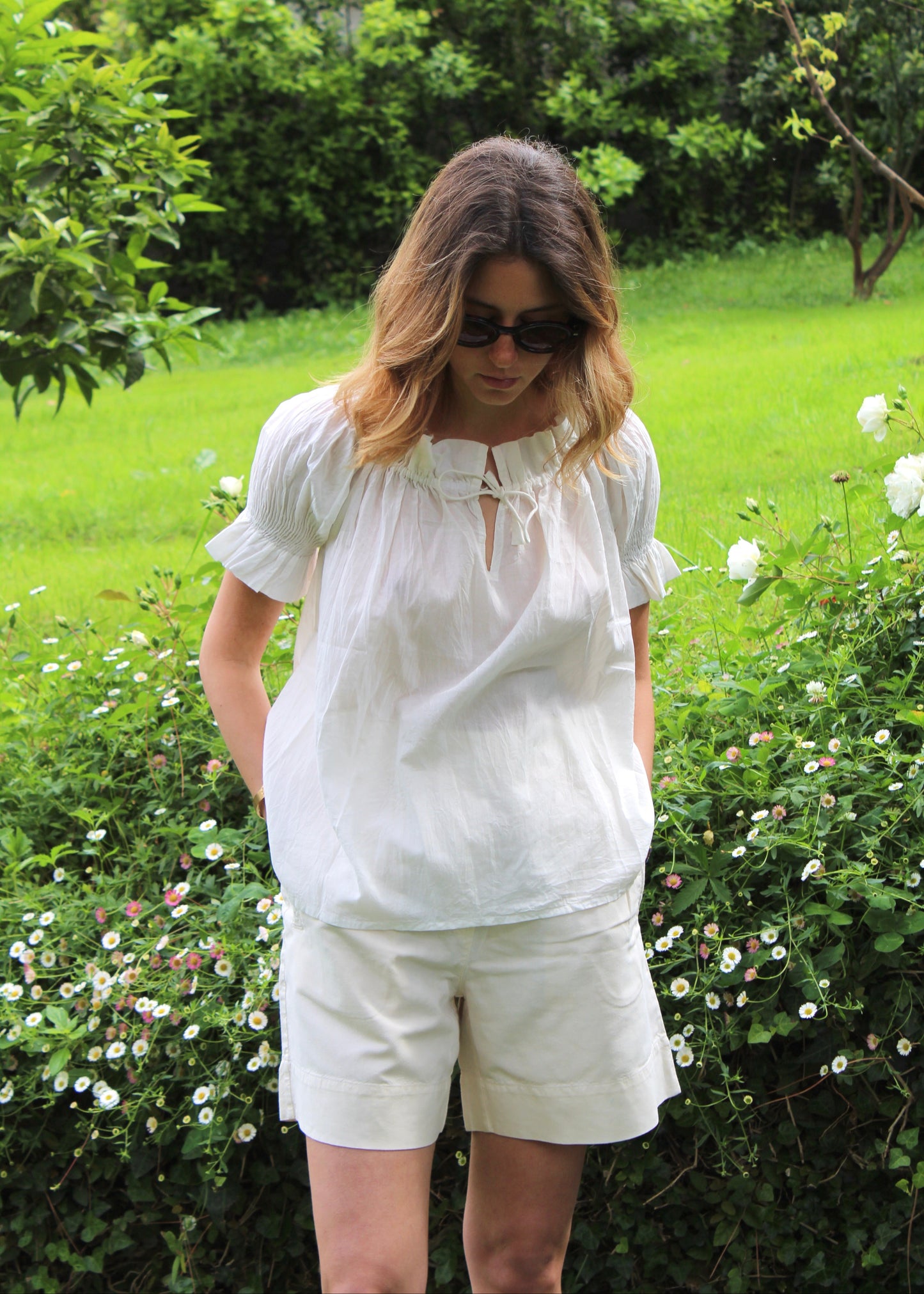 Blusa arricciata da donna in cotone bianco, modello Pimpa shirt di IGI AMA, 100% cotone, con laccetto sullo scollo e maniche elasticizzate a sbuffo, tessuto elastico che si adatta a tutte le corporature, prodotta in India, ideale per look estivi e casual.