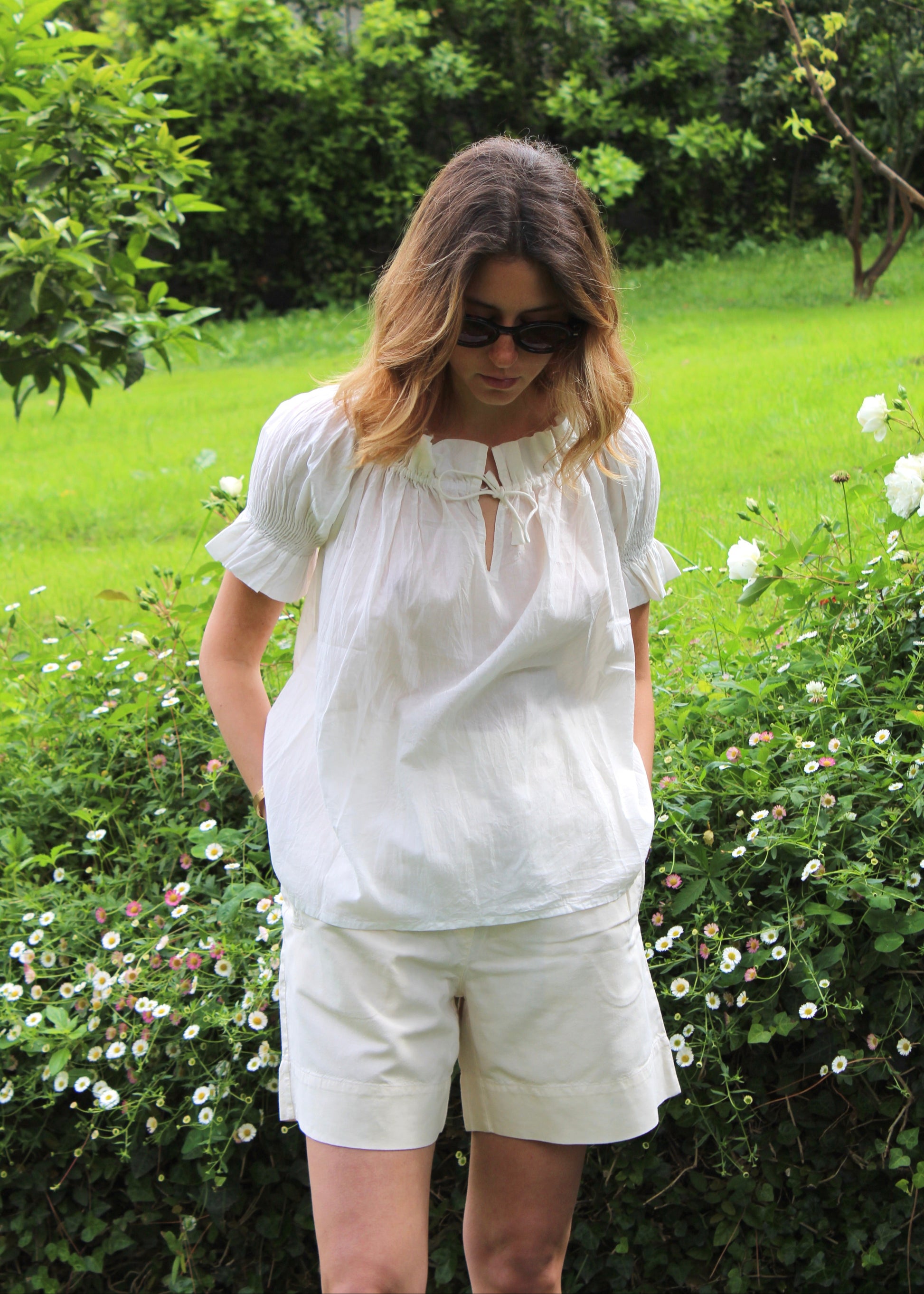 Blusa arricciata da donna in cotone bianco, modello Pimpa shirt di IGI AMA, 100% cotone, con laccetto sullo scollo e maniche elasticizzate a sbuffo, tessuto elastico che si adatta a tutte le corporature, prodotta in India, ideale per look estivi e casual.