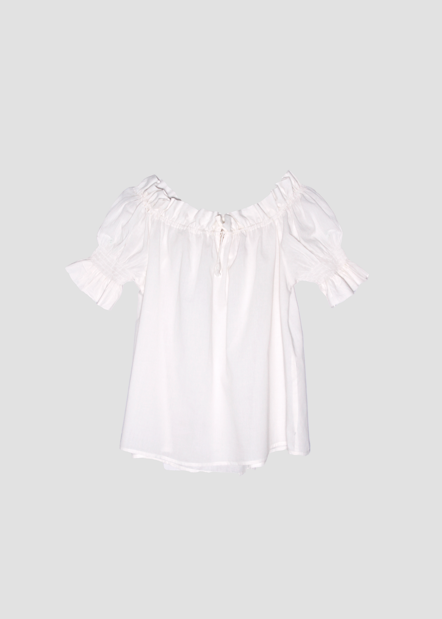 Blusa arricciata da donna in cotone bianco, modello Pimpa shirt di IGI AMA, 100% cotone, con laccetto sullo scollo e maniche elasticizzate a sbuffo, tessuto elastico che si adatta a tutte le corporature, prodotta in India, ideale per look estivi e casual.