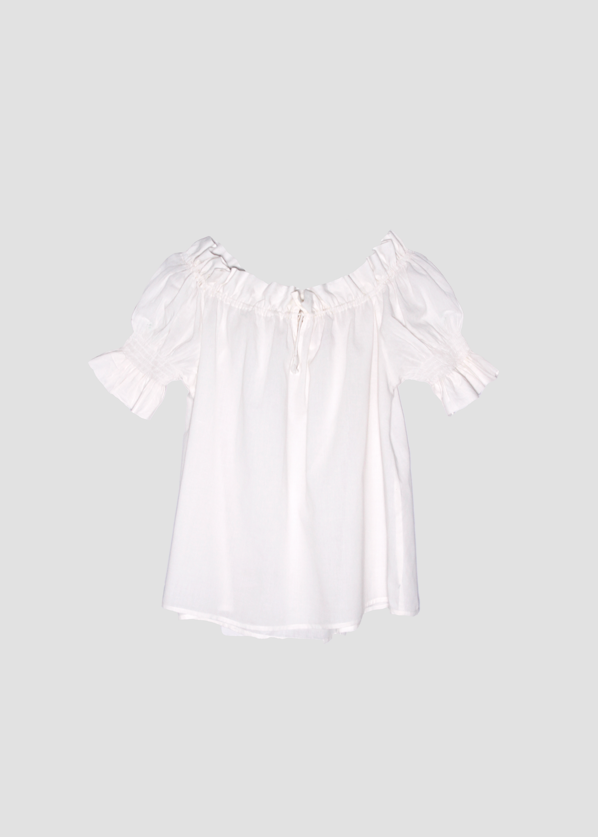 Blusa arricciata da donna in cotone bianco, modello Pimpa shirt di IGI AMA, 100% cotone, con laccetto sullo scollo e maniche elasticizzate a sbuffo, tessuto elastico che si adatta a tutte le corporature, prodotta in India, ideale per look estivi e casual.