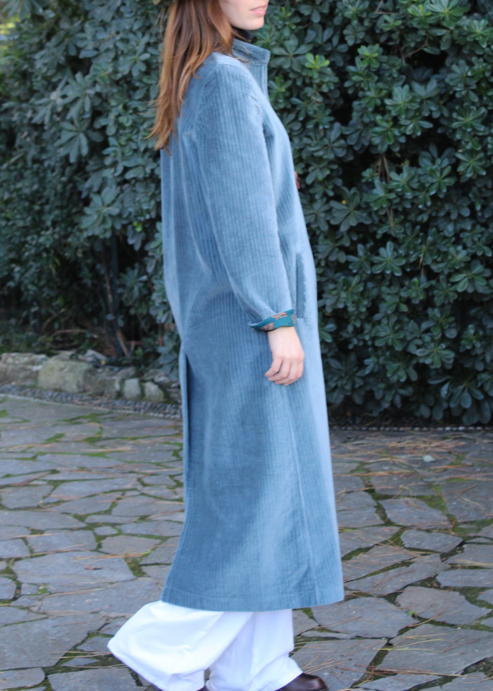 Alamari Coat in velluto azzurro carta zucchero di IGI Ama, cappotto azzurro con alamari marroni, collo alla coreana e bottoni a nodo. Spalle strutturate e fodera in poliestere. Prodotto in India, con un design elegante e raffinato. Lavare a secco, stirare a bassa temperatura, non candeggiare.