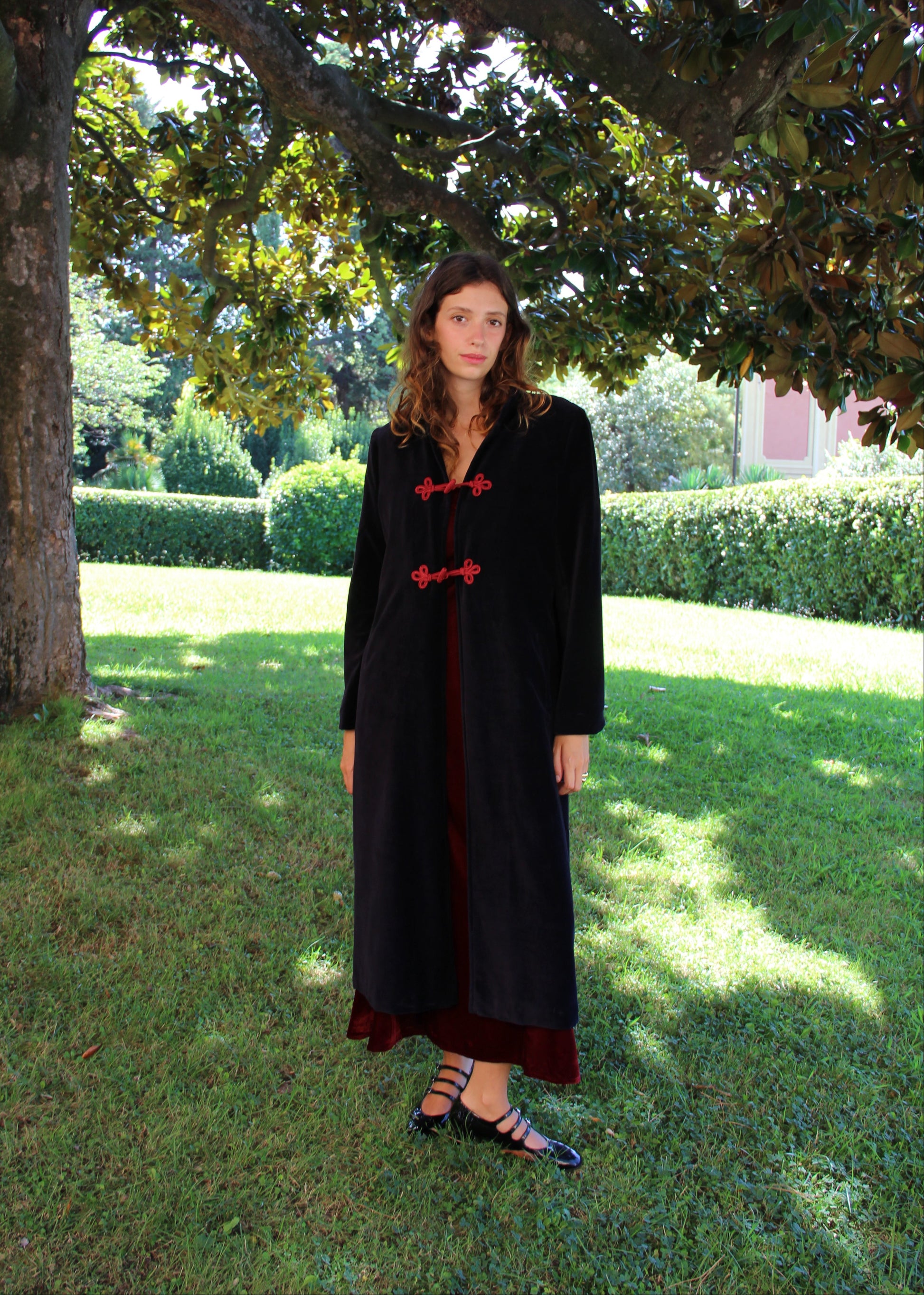Alamari Coat in velluto blu di IGI Ama, cappotto blu con alamari rosso, collo alla coreana e bottoni a nodo. Spalle strutturate e fodera in poliestere. Prodotto in India, con un design elegante e raffinato. Lavare a secco, stirare a bassa temperatura, non candeggiare.