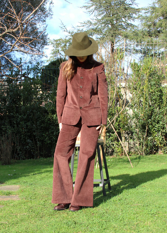 Abito in velluto a coste marrone 1970 Suit di IGI AMA, abito in velluto a coste marrone con giacca e pantaloni. Giacca con vita aderente, spalle strutturate e collo alla coreana. Fodera in poliestere, la modella è alta 170 cm e indossa una taglia S. Pantaloni in velluto a coste con pinces anteriori, vestibilità regolare, disponibili nelle taglie M e L. Prodotto in India con un design elegante e versatile. Solo lavaggio a secco, stiratura a bassa temperatura, non candeggiare.
