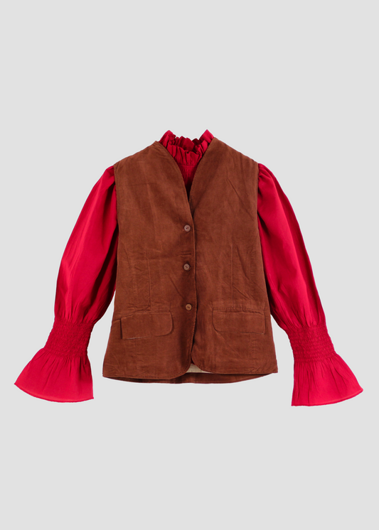 Gilet Madeleine in velluto a coste marrone di IGI Ama, smanicato marrone con fodera in cotone a motivo bianco e grigio. Realizzato in velluto a coste con fodera in cotone stampato. Stile elegante e raffinato, prodotto eticamente in India. Lavabile in lavatrice a 30°C, stirare a bassa temperatura.