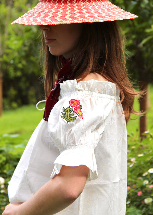 Pimpa Shirt di IGIAMA, blusa arricciata in 100% cotone con laccetto sullo scollo, maniche corte a sbuffo elasticizzate e fiori di montagna cuciti a mano, elastica e adatta a tutte le corporature, prodotta in India, perfetta per un look naturale e romantico.