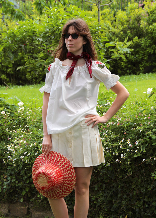 Pimpa Shirt di IGIAMA, blusa arricciata in 100% cotone con laccetto sullo scollo, maniche corte a sbuffo elasticizzate e fiori di montagna cuciti a mano, elastica e adatta a tutte le corporature, prodotta in India, perfetta per un look naturale e romantico.