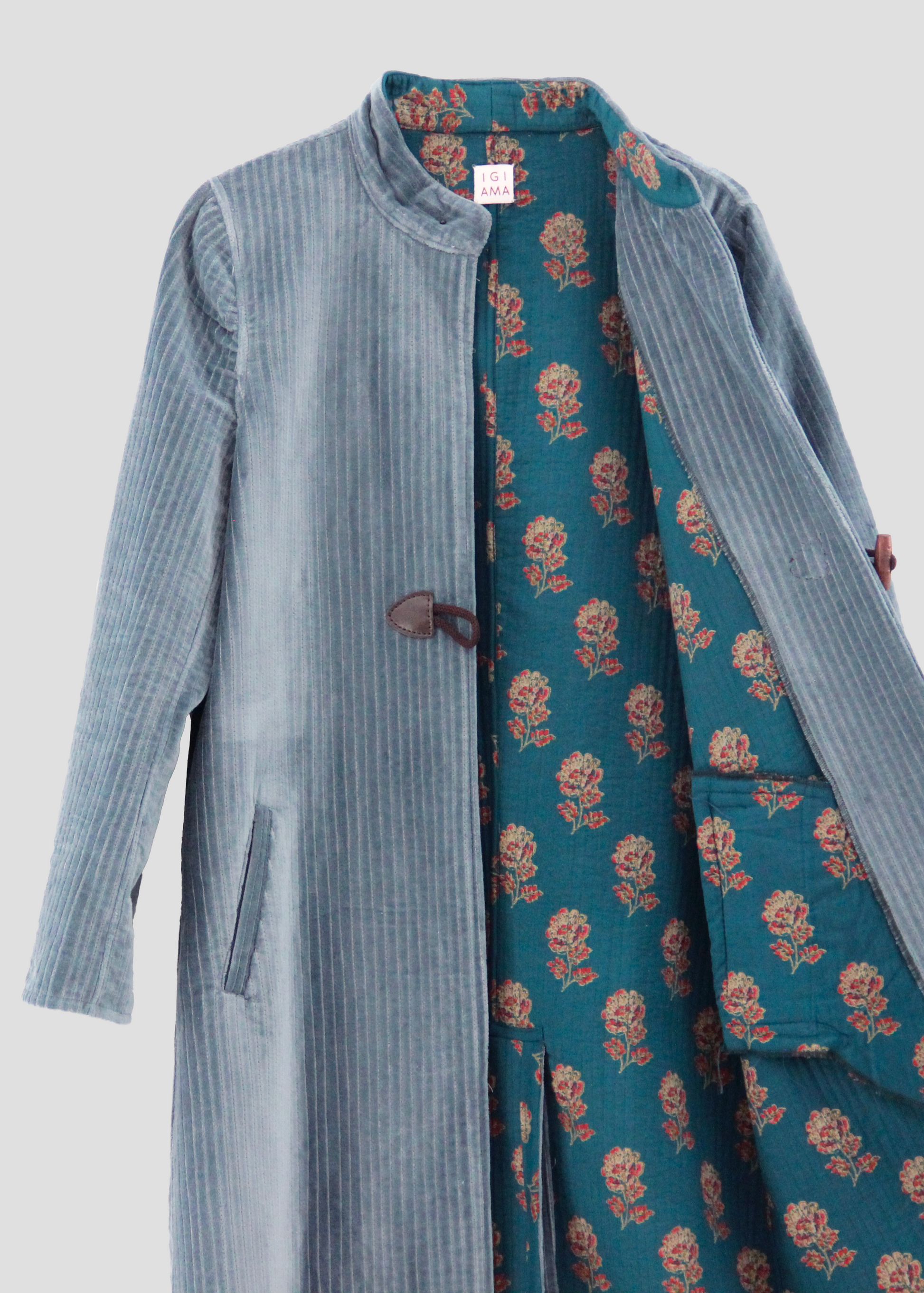 Alamari Coat in Light sky blue/wood Alamari, velvet light blue coat with wood alamari, mandarin collar, and frog buttons. Structured shoulders and polyester lining. Made in India with an elegant and refined design. Dry clean only, iron on low heat, do not bleach.