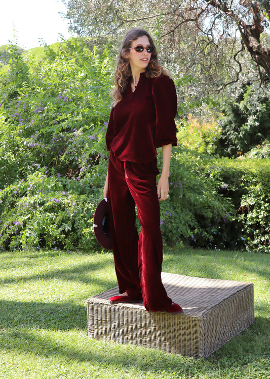 Set autunno/inverno da donna IGI AMA in velluto bordeaux, composto da blusa Bohémien con scollo con chiusura a bottoni in tessuto e maniche lunghe elasticizzate sul polso, e pantaloni in velluto da portare a vita alta o bassa con vestibilità comoda adatta a tutte le corporature, 100% velluto, taglia unica (veste una M), perfetto per outfit vintage chic, look boho radical e abbinamenti eleganti per la stagione fredda.