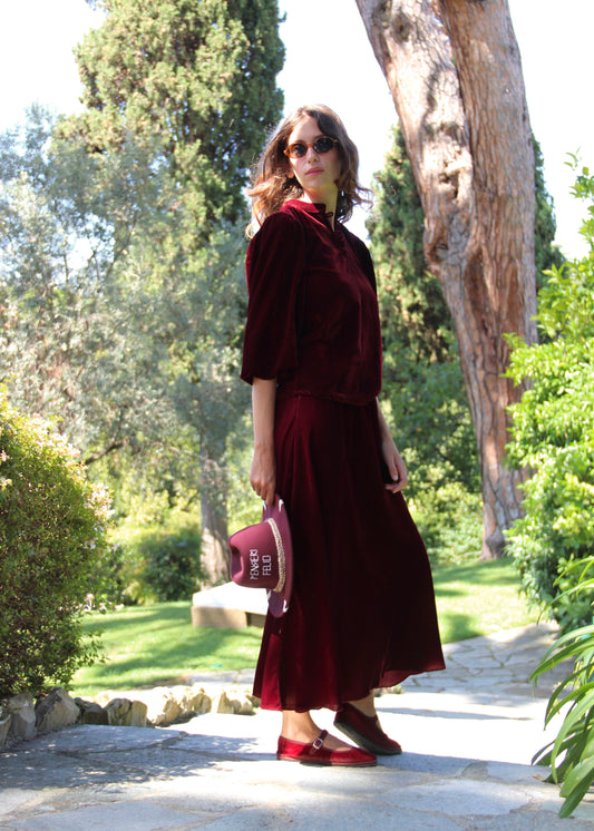 Set autunno/inverno da donna IGI AMA in velluto bordeaux, composto da blusa Bohémien con scollo con chiusura a bottoni in tessuto e maniche lunghe elasticizzate sul polso, e gonna lunga fino alla caviglia con elastico in vita, 100% velluto, taglia unica (veste una M), perfetto per outfit vintage chic, look boho radical e abbinamenti eleganti per la stagione fredda.