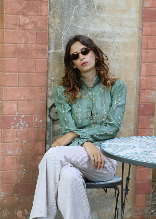 Camicetta verde in cotone 100% fantasia Ikat – IGI AMA x Orienthera. Camicia donna artigianale prodotta in India, leggera e versatile. Lavabile a 30°C e facile da stirare a bassa temperatura.