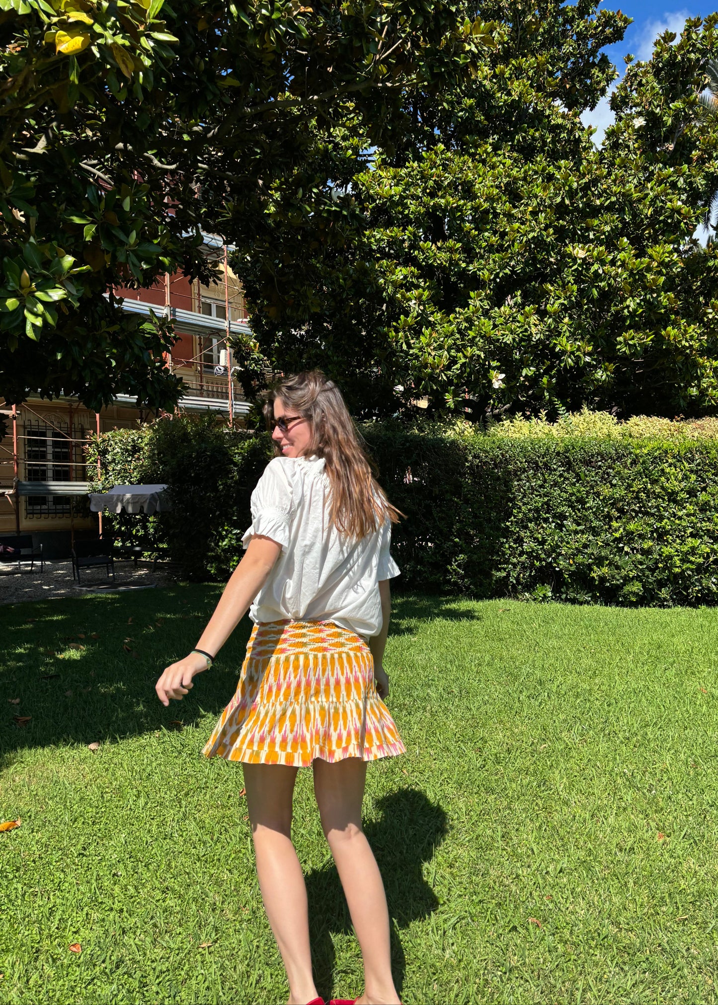 La Mola Skirt, boho chic cream-colored skirt with an oval pattern in yellow, orange, green, and pink. Elastic waistband for a comfortable fit. Made in India from 100% patterned cotton. A reinterpretation of ethnic style with a vintage touch. Machine washable at 30°C, low-heat ironing.